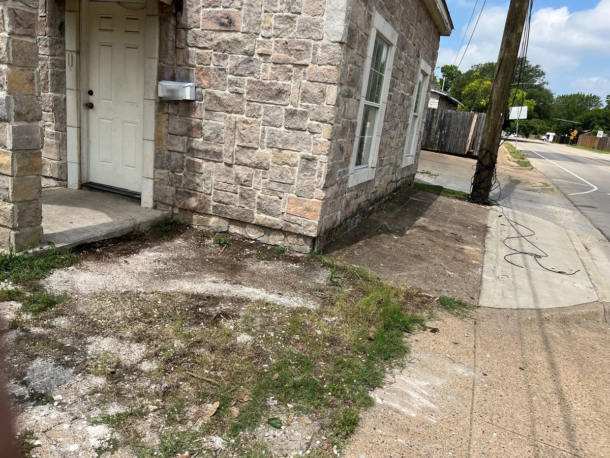 Same side of the stone house swept clear after haul-away
